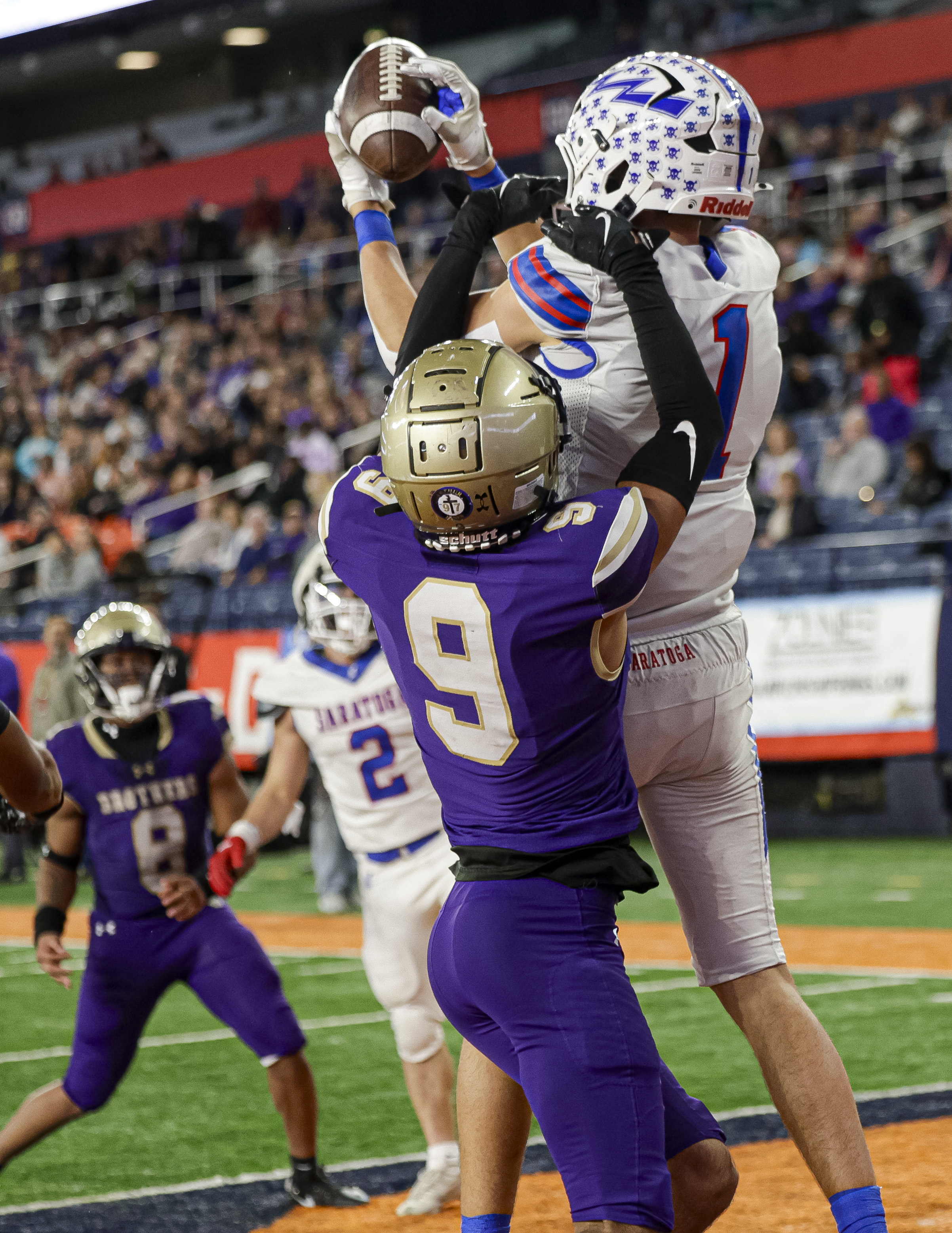 Saratoga Springs Blue Streaks Gavin Lafrance (1) scores a touchdown over CBA Brothers WRDB Adrian Weather (9) as the CBA Brothers and Saratoga Springs Blue Streaks fought for the New York State Class AA state title at JMA Wireless Dome Saturday, December 6, 2025. (N. Scott Trimble | strimble@syracuse.com)