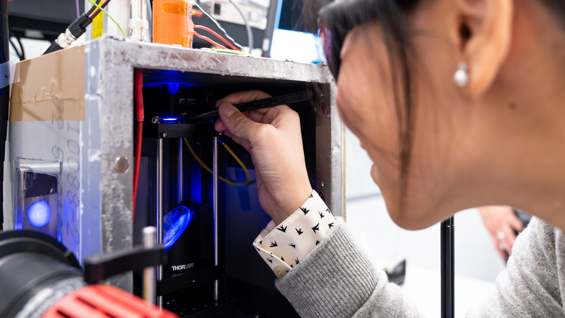 Sue Shi, ISTA PhD student, places a particle inside the acoustic levitation setup.