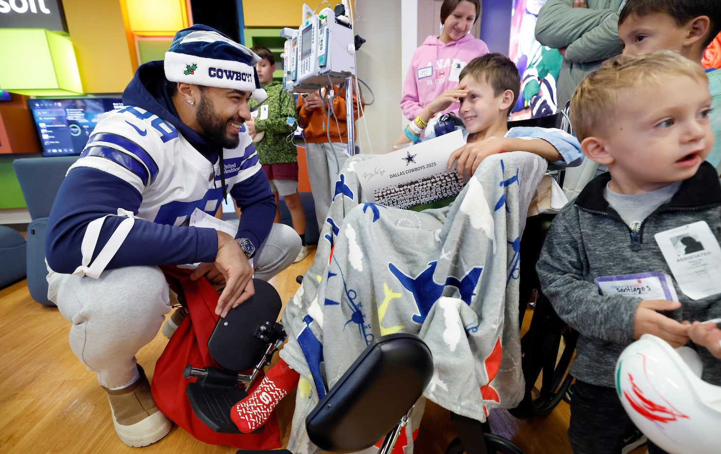 Pedro Solorzano, 8, of DeSoto (in chair) receives a signed team photo from Dallas Cowboys...