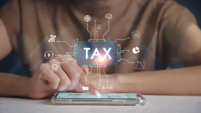 Finger touching screen on smartphone scan Online personal income tax icon for tax payment. Government data analysis document. stock photo