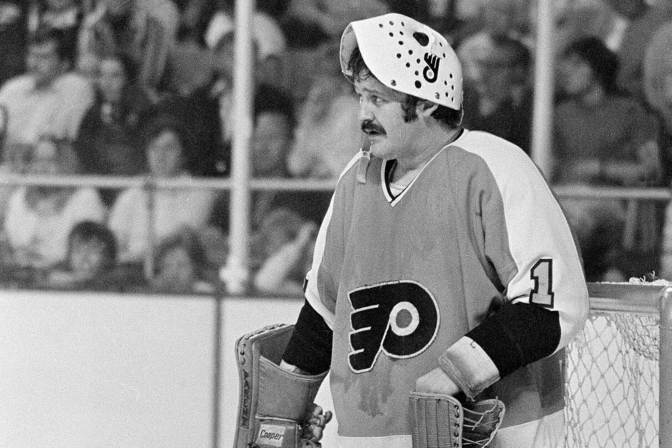 Philadelphia Flyers goalie Bernie Parent raises his mask
