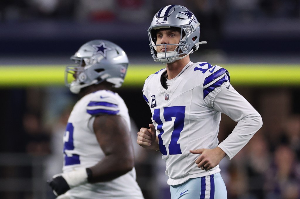 Dallas Cowboys kicker Brandon Aubrey in a white and blue uniform reacts after a missed field goal.