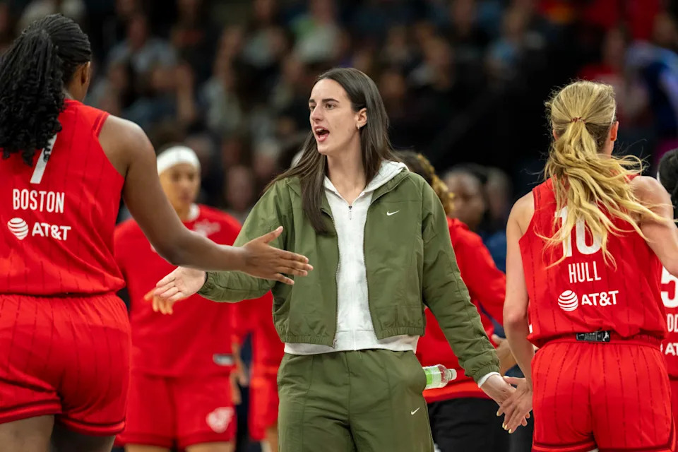 Indiana Fever guard Caitlin Clark (22) shakes hands with Indiana Fever forward Aliyah Boston (7) and Indiana Fever guard Lexie Hull (10) during a timeout.© Jesse Johnson-Imagn Images