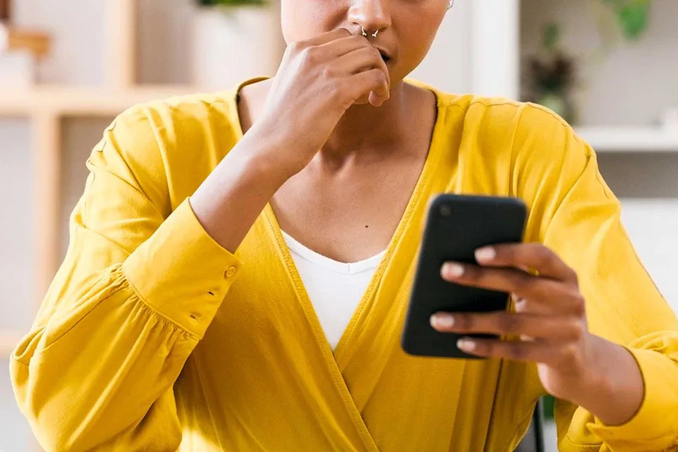 Getty Stock Images Woman worriedly checking her phone (stock image)