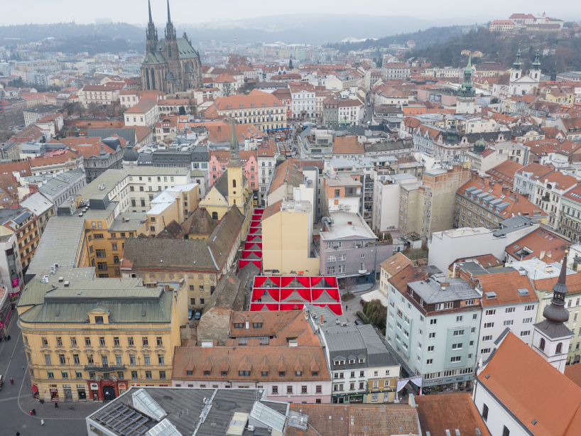 red and white curtains transform czech historic center’s pathways into christmas installation