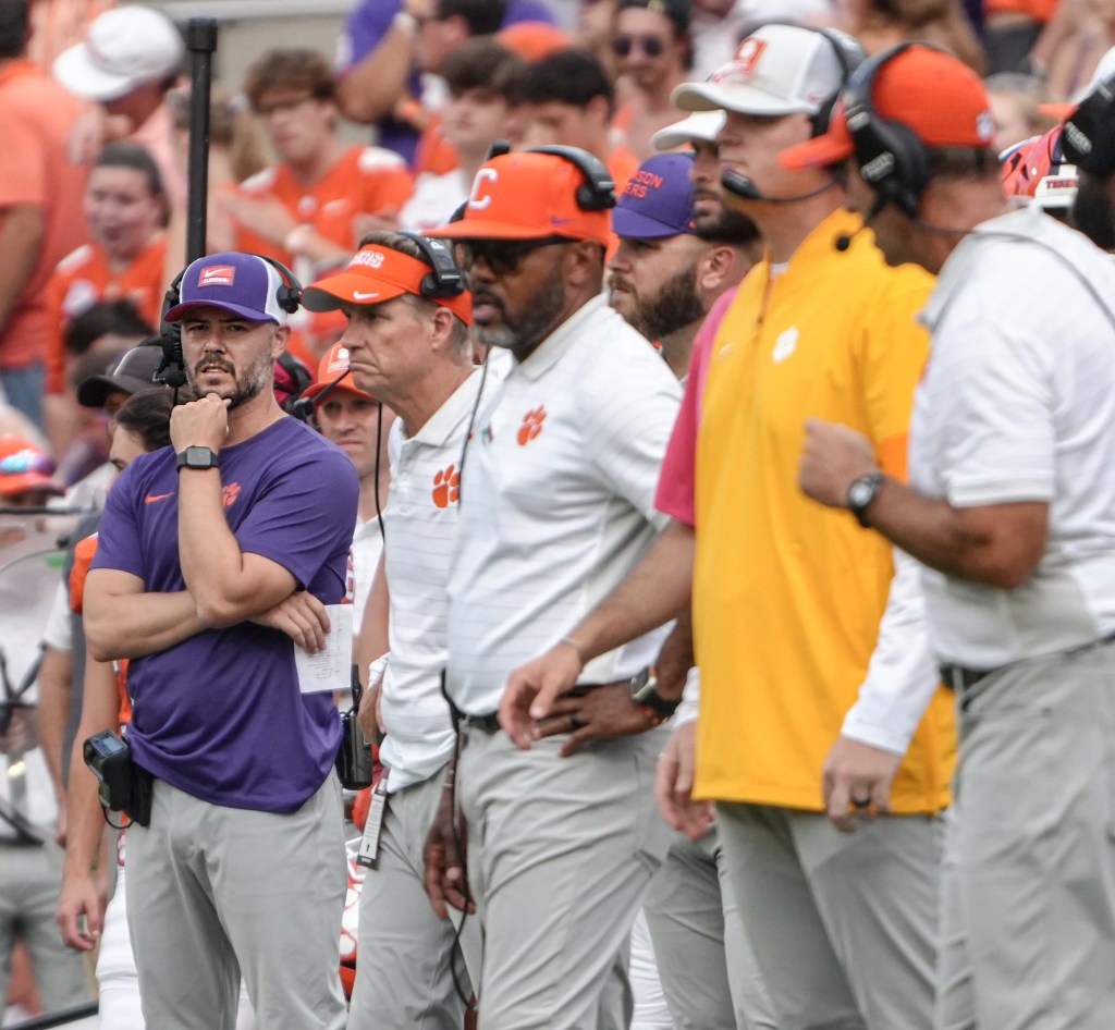 Clemson Tigers offensive coordinator Garrett Riley and other coaches on the sideline.