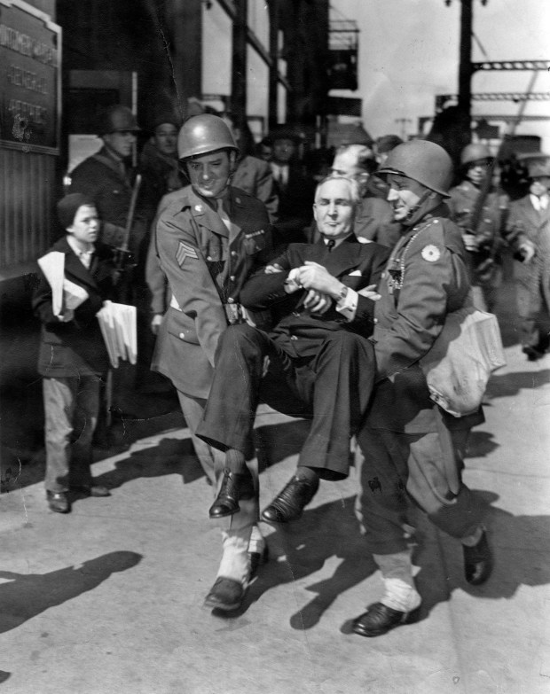 Soldiers carry Sewell Avery, chairman of the board of Montgomery Ward & Co., out of the building on April 27, 1944, after he was removed from his own office by the army on instructions of Atty. Gen. Biddle. Avery had defied the department of commerce when it tried to take over the huge plant. (Fred Giese/Chicago Tribune) 
