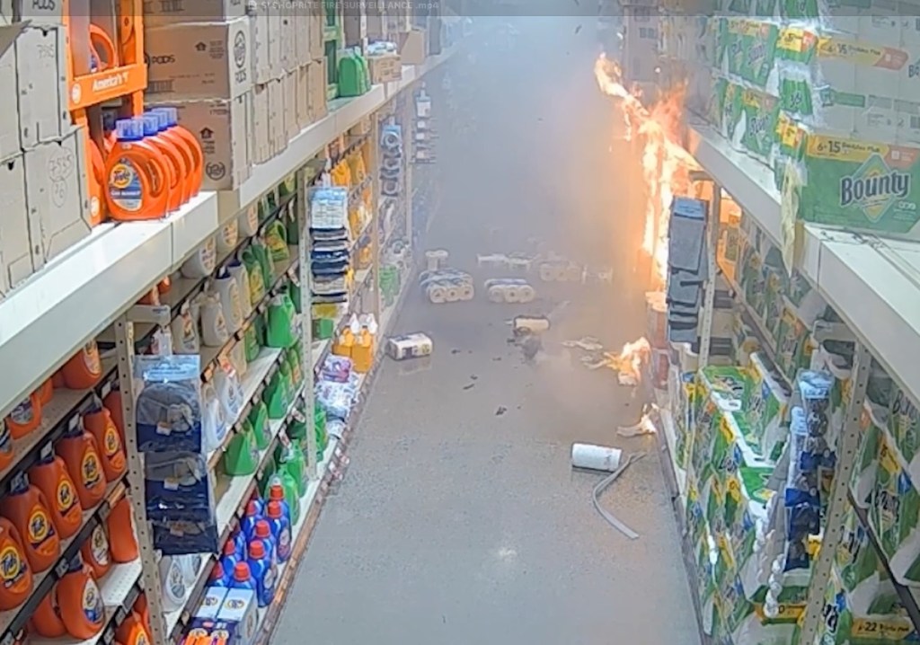A fire in a ShopRite aisle with shelves of laundry detergent and paper products.