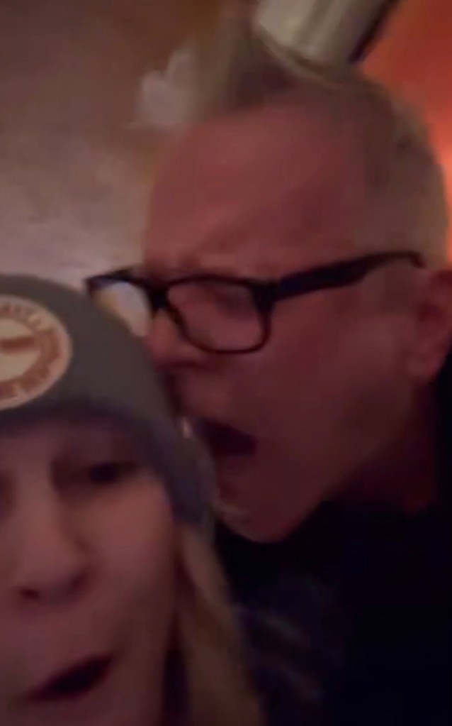 Max Towey in black-rimmed glasses yelling at a woman wearing a beanie.