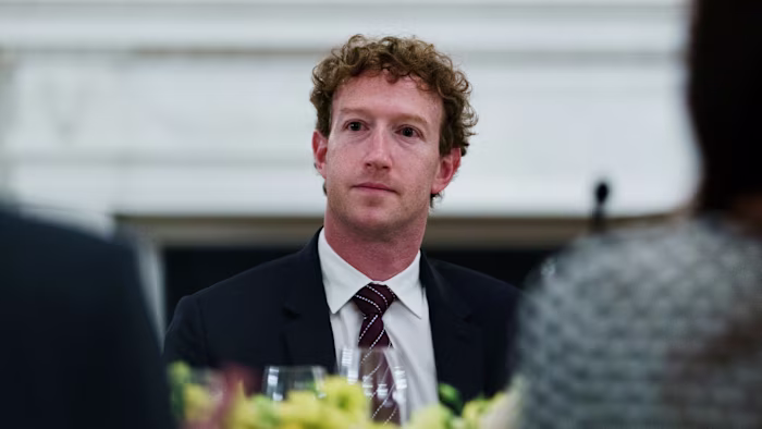 Mark Zuckerberg sits at a dinner table, looking ahead, during a gathering with tech leaders at the White House.