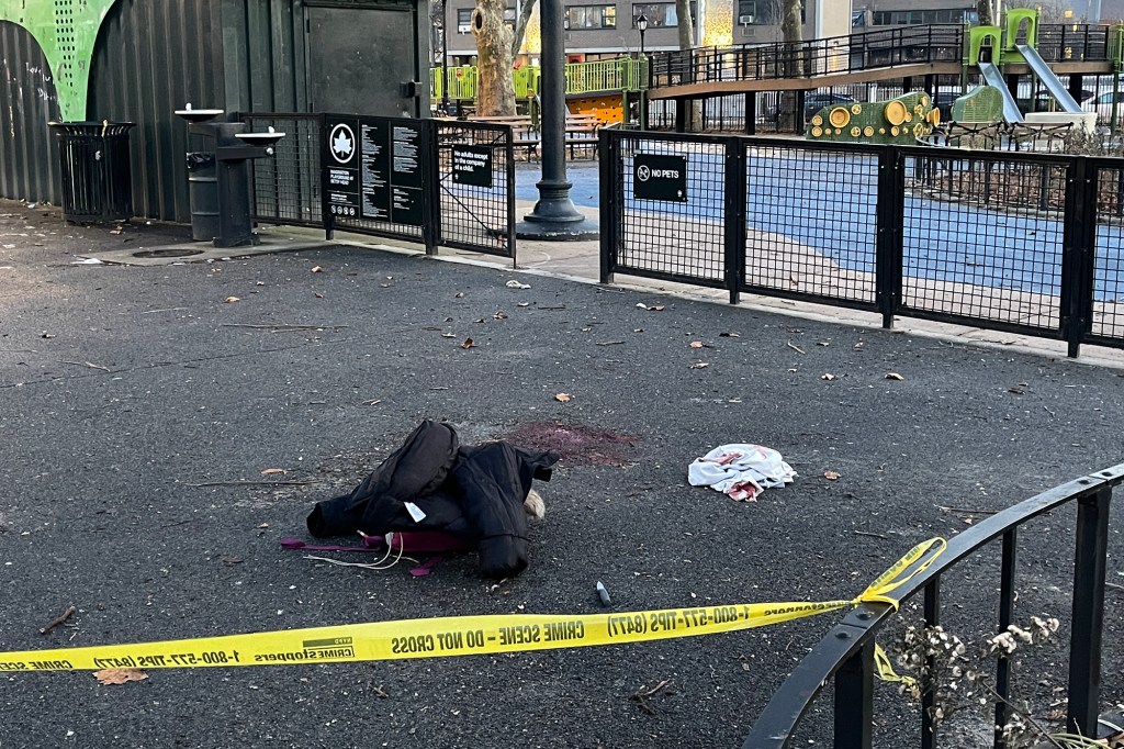 Evidence of a crime scene at an intersection near a playground, with yellow crime scene tape, clothing, and blood on the ground.