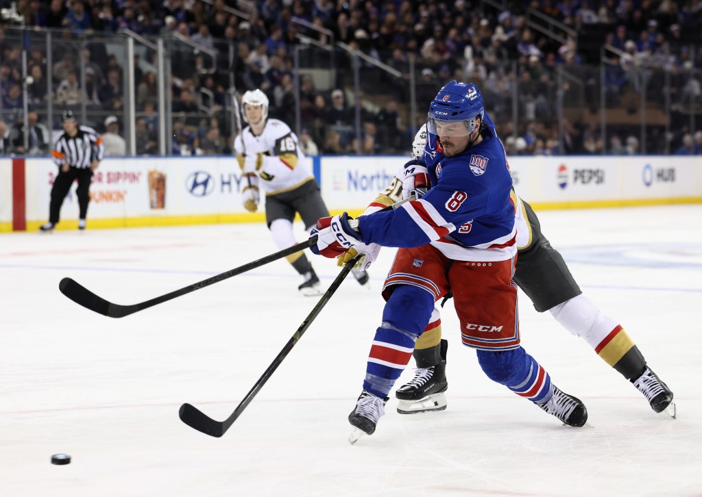 J.T. Miller of the New York Rangers skating with the puck in a hockey game.