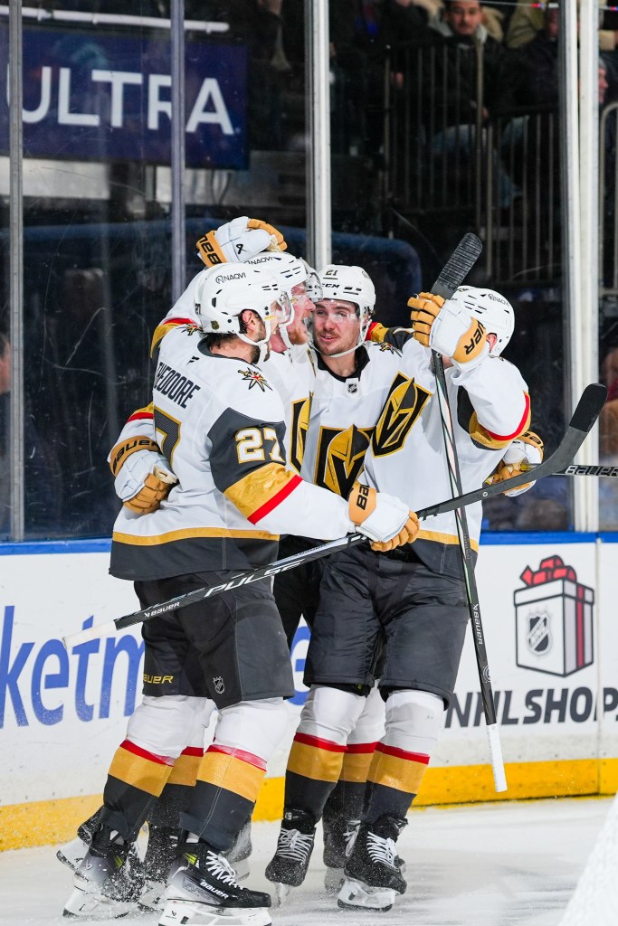 Vegas Golden Knights players Jack Eichel, Shea Theodore, and teammates celebrating a goal.