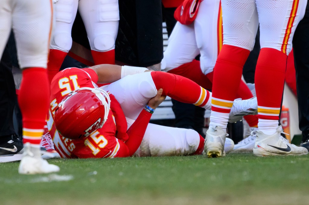 Kansas City Chiefs quarterback Patrick Mahomes on the ground grabbing his knee after being injured.