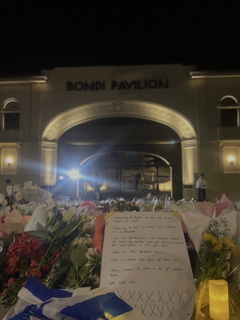 A bunch of flowers with a note that reads: "Choosing to hate, in any way, never made us safer."Choosing to love, in every way, makes us unstoppable."We, as Australians, will also choose to love, no matter who you believe, where you come from, or who you love."And in this darkest hour,"Let us share the light of those lost,"And release it into a sky of infinite love."We will rise."