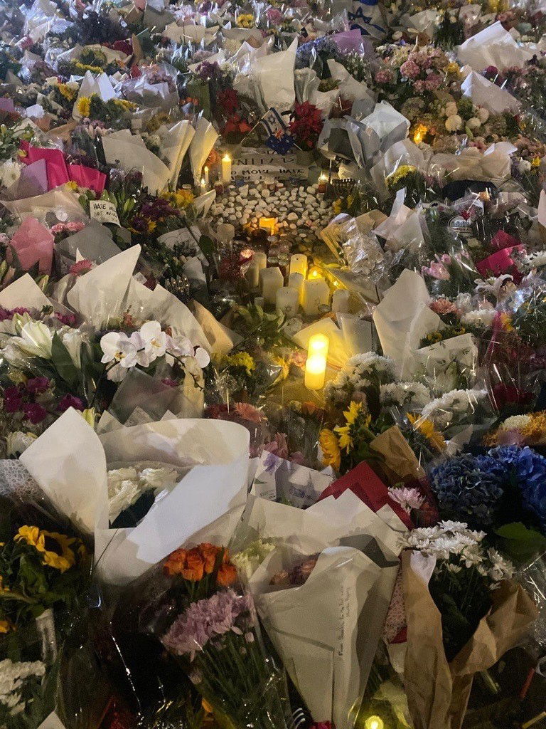 Dozens of bunches of flowers sit on the ground