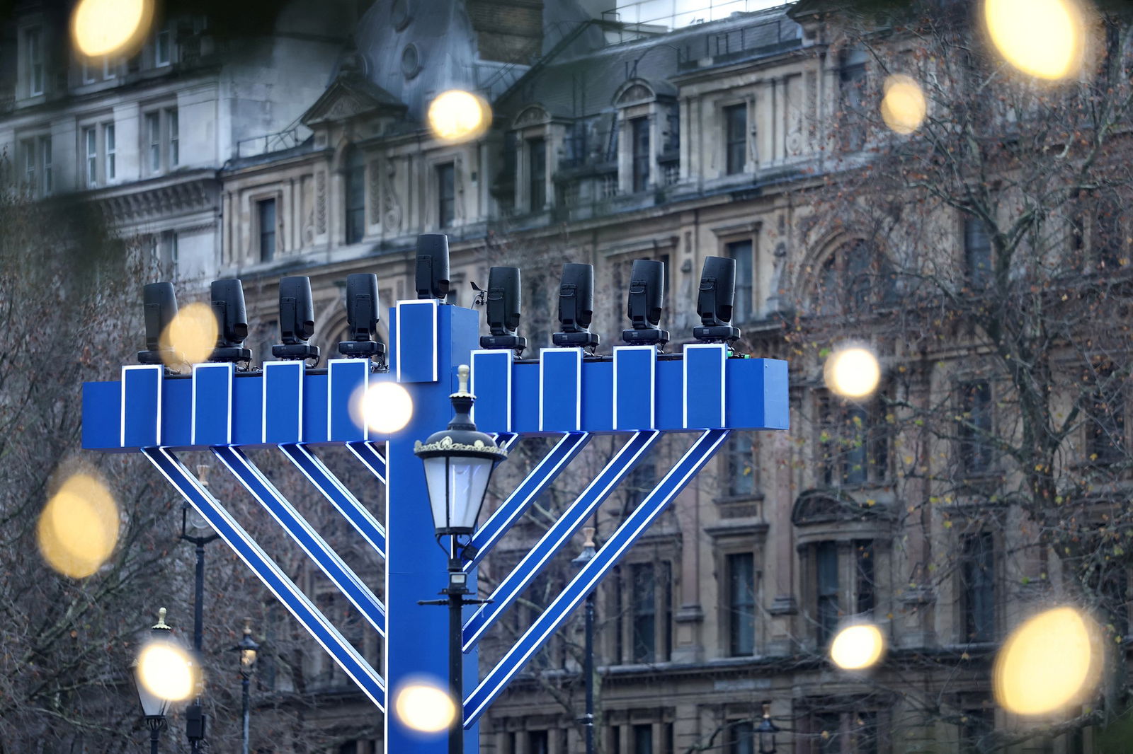 The top of a large menorah with lights on top