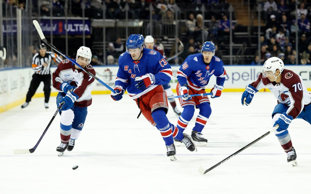 New York Rangers left wing Alexis Lafrenière moves the puck down ice as Colorado Avalanche Devon Toews tries to steal in the first period.