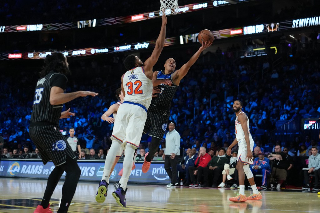 Orlando Magic guard Desmond Bane drives to the basket as New York Knicks center Karl-Anthony Towns defends.