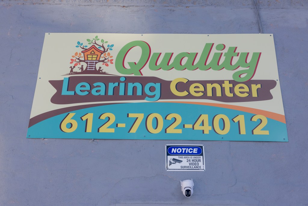 Quality Learning Center sign and a security camera in Minneapolis, Minnesota.