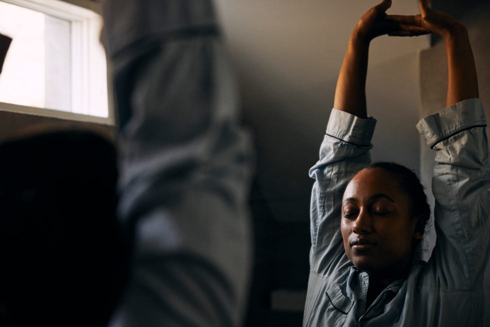 easy fitness resolutions: woman stretching in bathroom mirror