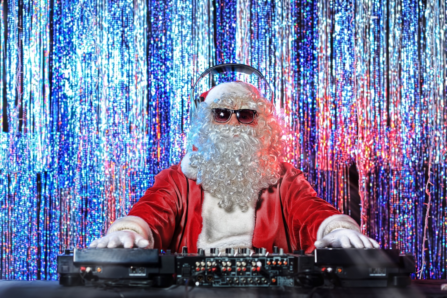 DJ Santa Claus mixing up some Christmas cheer. Disco lights in the background.