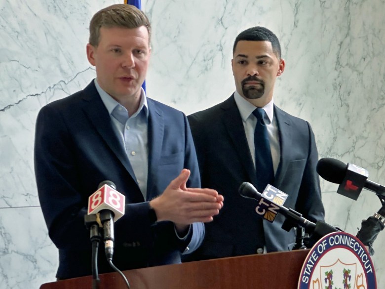 Men in suits speaking at lectern