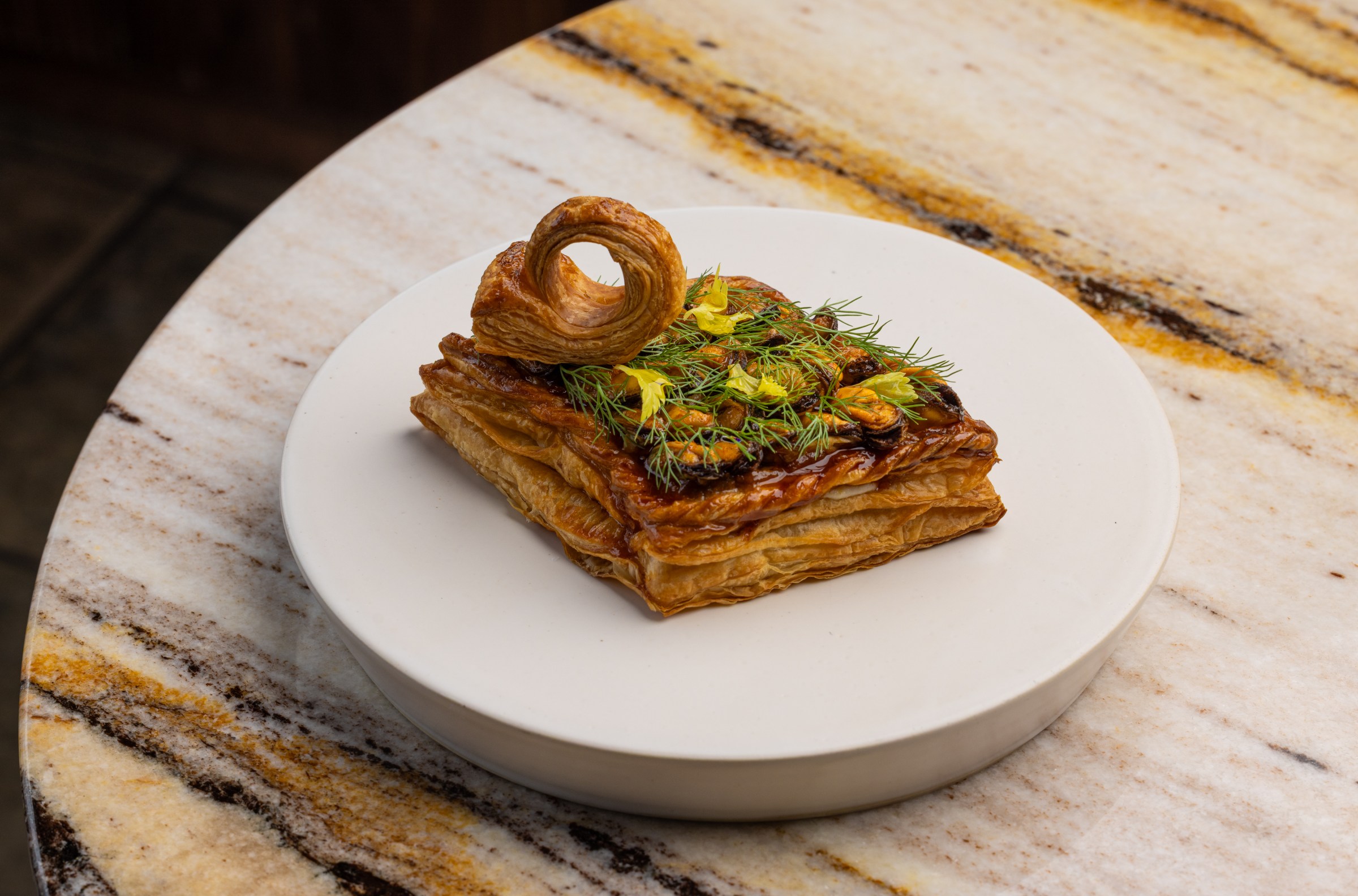 Side angle of mussels tart with laminated crust at Vin Folk.