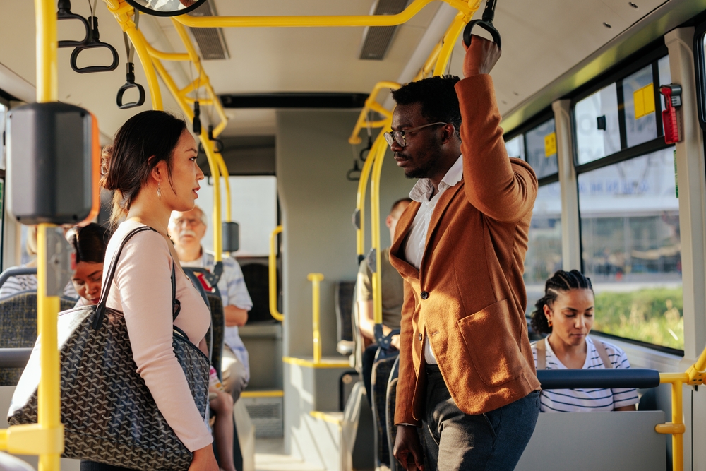 man and woman conversing on a bus.