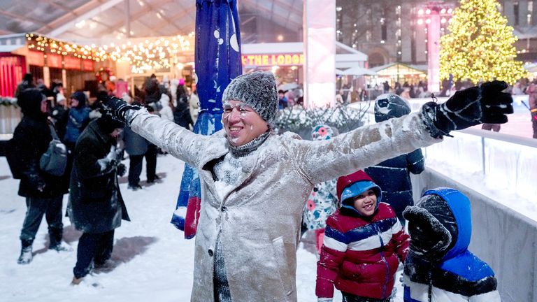 A person smiles after being covered with snow from a snowplough. Pic: Reuters