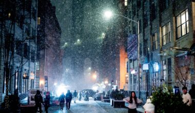 People gather on Washington Street, Brooklyn, as snow falls. Pic: Reuters