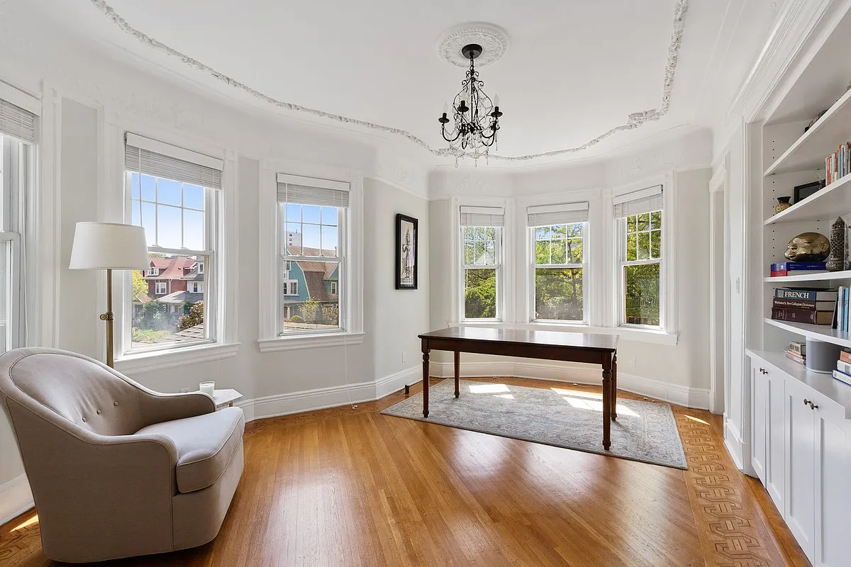 bedroom with plaster details on ceiling, wood floor