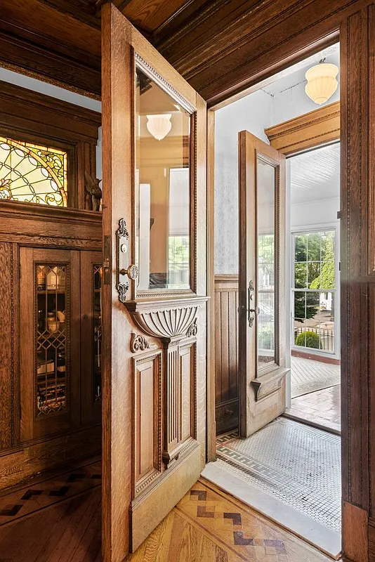 original ornate door open to a tiled foyer