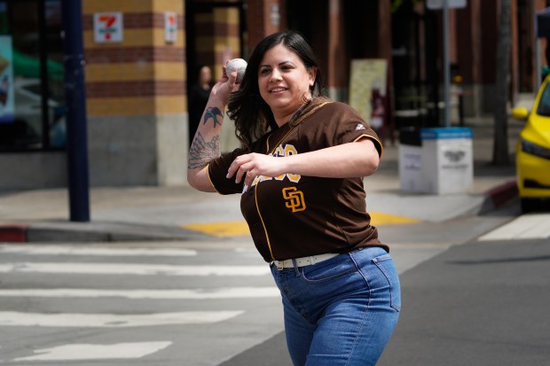 Divina Rodriguez of Chula Vista tried her luck at baseball pitching while at the 13th Annual East Village Block Party on Saturday, March 29, 2025, in San Diego, CA. (Nelvin C. Cepeda / The San Diego Union-Tribune)