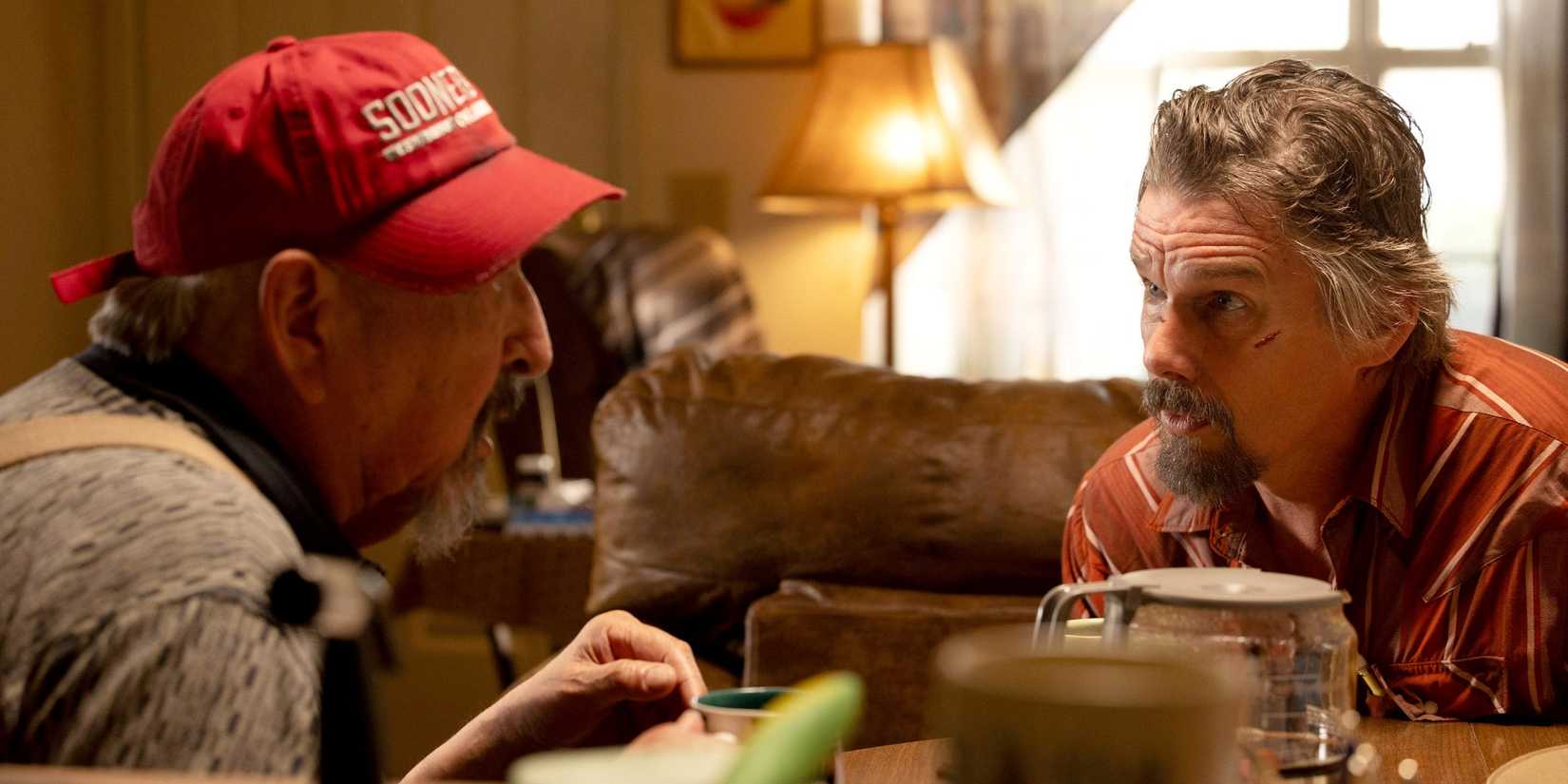 Ethan Hawke as Lee Raybon sitting at a table across from Graham Greene as Arthur Williams in The Lowdown