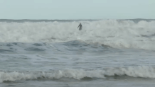 A surfer off Tourmaline Beach attempts to ride a wave, Saturday, as the ocean churns beneath him, La Jolla, Calif., December 27, 2025.