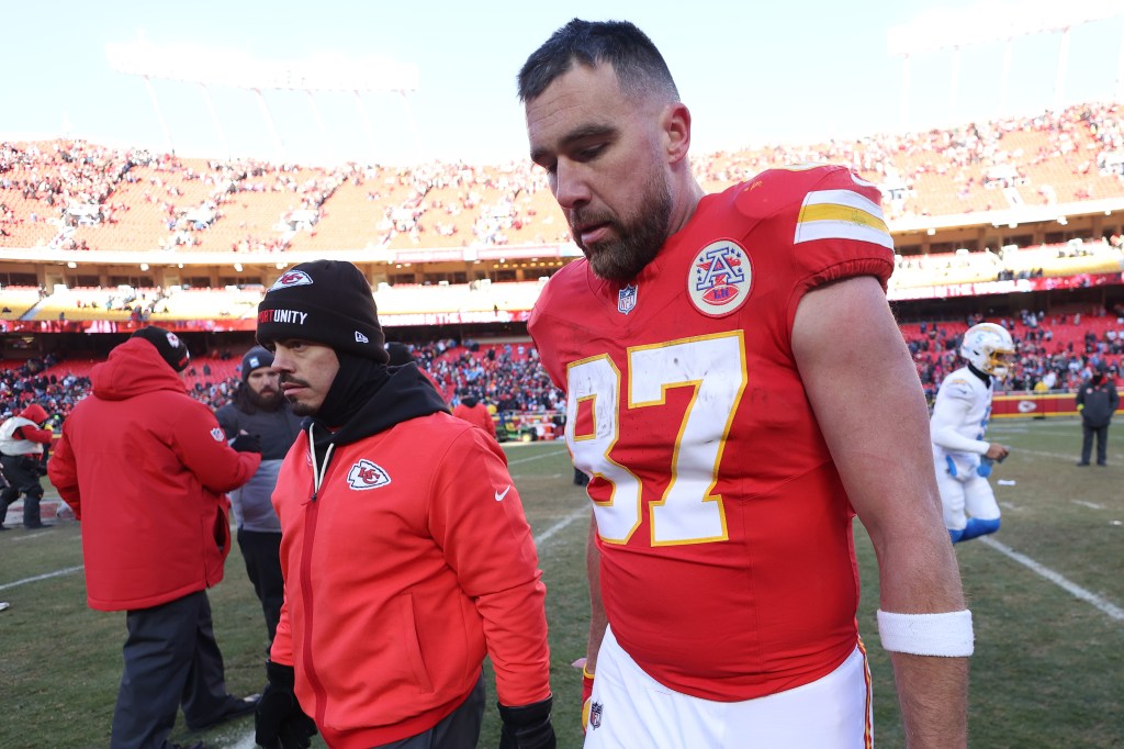 Travis Kelce, wearing a red Kansas City Chiefs jersey with the number 87, walks off the field after losing a game.