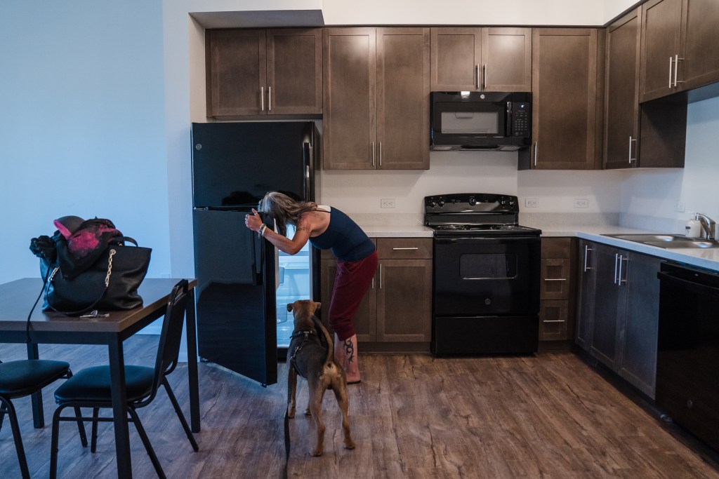 Rachel Hayes with her dog Nino in her new apartment in San Ysidro on June 20, 2023.