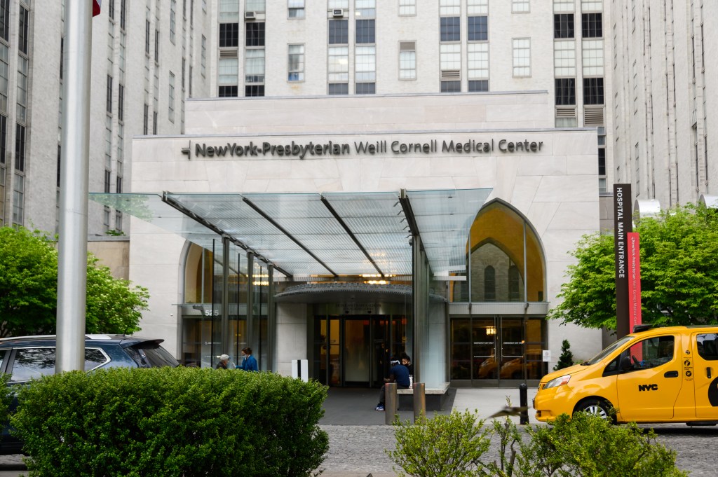The entrance of NewYork-Presbyterian Weill Cornell Medical Center with a yellow cab parked outside.