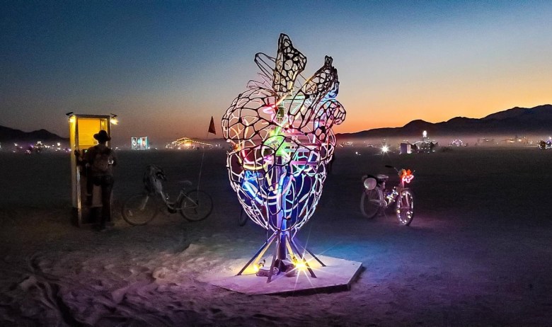A sculptural art installation in the desert with neon lights
