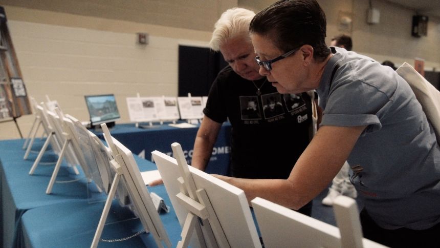 Sue Decker, right, and her partner Sherry Combs, who lost their home of more than two decades in the fire, attend a resource fair for fire victims.