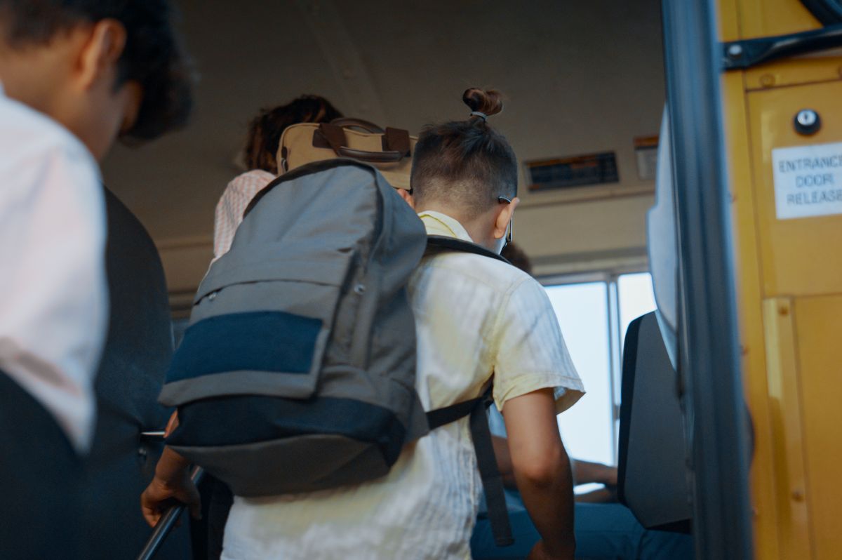 Group of diverse pupils board schoolbus