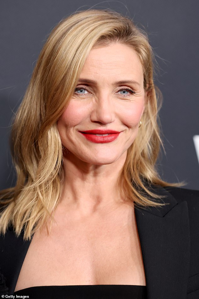 Rocking a bold red lip, the blonde bombshell strutted her stuff in a chic low-cut dress worn under a classic black blazer