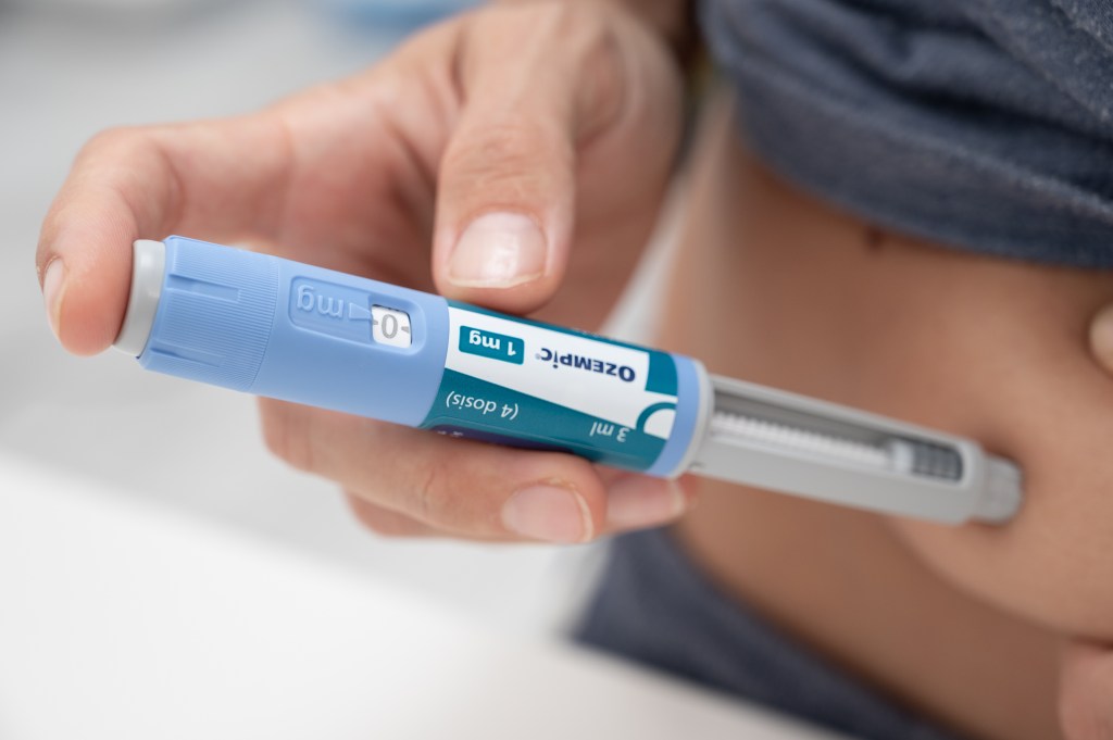 Close-up of a person injecting Ozempic for diabetes and weight loss treatment.