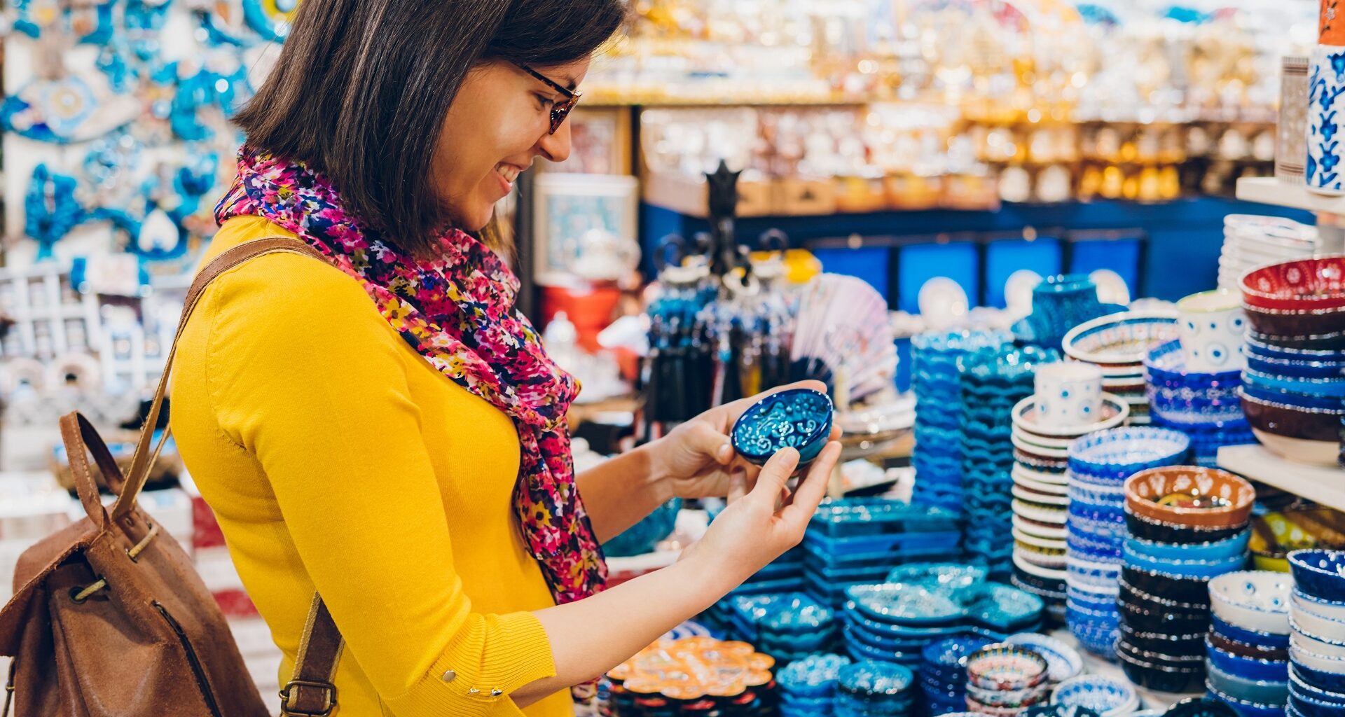 Woman dressed in bright colors, holding a small bowl, shopping in bazaar market, Istanbul stock photo