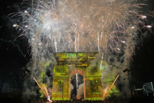 A light show is projected on the Arc de Triomphe as fireworks explode during New Year celebrations on the Champs Elysees, in Paris, France, Thursday, Jan. 1, 2026. (AP Photo/Christophe Ena)