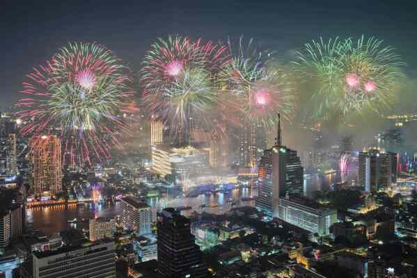 Fireworks explode over the Chao Phraya River during New Year celebrations in Bangkok, Thailand, Thursday, Jan. 1, 2026. (AP Photo/Sakchai Lalit)