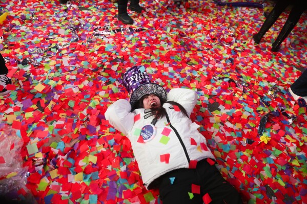 Sora Honda lays on the confetti-covered sidewalk as she celebrates the start of 2026 during New Year's Eve festivities, Thursday, Jan. 1, 2026, in New York. (AP Photo/Heather Khalifa)