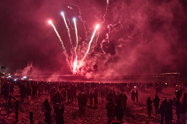 People watch fireworks at the beach of the Baltic Sea in Timmendorfer Strand, Germany, early Thursday, Jan. 1, 2026. (AP Photo/Michael Probst)