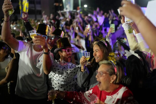 People celebrate the New Year in Caracas, Venezuela, Thursday, Jan. 1, 2026. (AP Photo/Matias Delacroix)